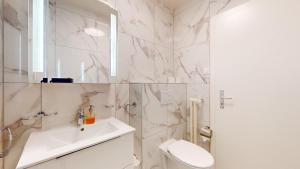 a white bathroom with a sink and a toilet at Modern studio in the heart of Geneva in Geneva