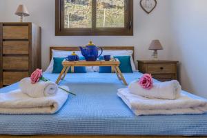 sypialnia z 2 łóżkami z ręcznikami i stołem w obiekcie Blue Bay Villas , First Floor w mieście Archangelos