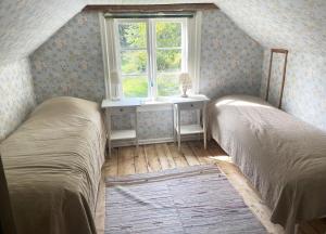 two beds in a room with a window at Cozy holiday home in Tranas, Odeshog in Tranås