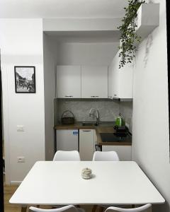 uma cozinha com uma mesa branca e cadeiras em Beratinus Apartment em Berat