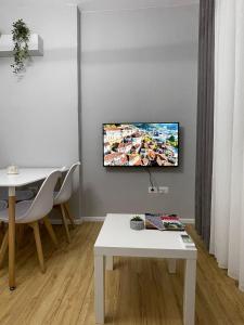 uma sala de estar com uma televisão na parede em Beratinus Apartment em Berat