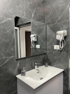 uma casa de banho com um lavatório e um espelho em Beratinus Apartment em Berat