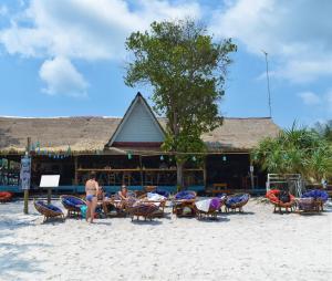 een groep mensen die in stoelen op het strand zitten bij The Big Easy Koh Rong Samloem in Koh Rong Sanloem