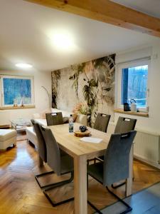a dining room with a wooden table and chairs at Ferienhaus am Wald in Wendehausen
