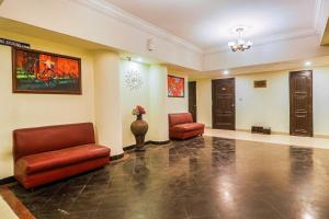 a lobby with two leather chairs and a door at Townhouse Hotel Taksonz in Ludhiana