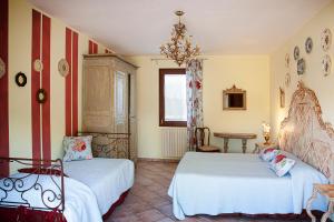 2 Betten in einem Zimmer mit gelben und roten Streifen in der Unterkunft Agriturismo Forzello in Ariano nel Polesine