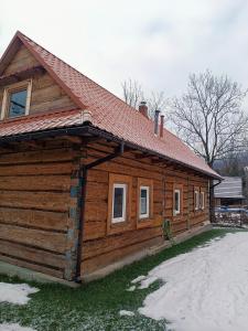 una cabaña de madera con nieve en el suelo frente a ella en Dom w górach do wynajęcia, Poręba,Koninki ,1h drogi,50 km od Krakowa., en Poręba Wielka