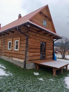 une petite cabane en rondins avec une rampe en face de celle-ci dans l'établissement Dom w górach do wynajęcia, Poręba,Koninki ,1h drogi,50 km od Krakowa., à Poręba Wielka