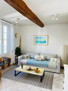 Sala de estar con sofá azul y mesa de centro en Pimms Apartment, en Antibes