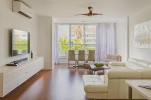 a living room with a couch and a tv at Tiran Square Haven - Herzliya Pituach in Herzliya B