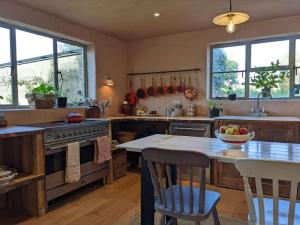 una cocina con una mesa con un bol de fruta. en Stylish 3 bed Cotswold cottage with stunning views, en Cheltenham