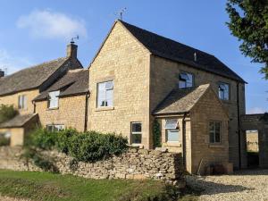a large brick house with a stone wall at Stylish 3 bed Cotswold cottage with stunning views in Cheltenham