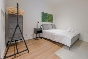 a white bedroom with a bed and a ladder at Modern Apt & Cool interior design a 20 metros del Retiro in Madrid