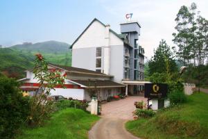 a large white building with a sign in front of it at Hotel C7 Munnar in Munnar