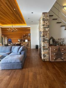 a living room with a blue couch and a stone wall at The Lake House 野尻湖 in Shinano