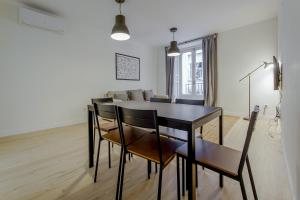 comedor y sala de estar con mesa y sillas en Modern Apt para 6pax en la Plaza de Tirso-Centro, en Madrid