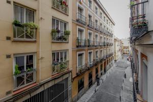 Modern Apt para 6pax en la Plaza de Tirso-Centro في مدريد: زقاق في مبنى الشقق مع الزهور