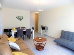 een woonkamer met een bank en een tafel bij Royan - APPARTEMENT avec EMPLACEMENT IDEAL - terrasse - garage privatif in Royan