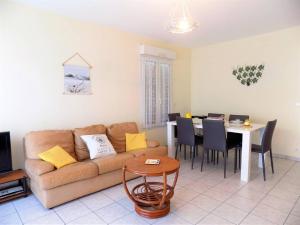 een woonkamer met een bank en een tafel bij Royan - APPARTEMENT avec EMPLACEMENT IDEAL - terrasse - garage privatif in Royan