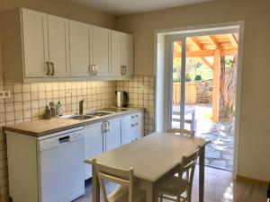 a kitchen with white cabinets and a table and a table and chairs at Villa La casa del gat in Mosset