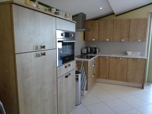 Una cocina con electrodomésticos de acero inoxidable y gabinetes de madera. en Appartement vue mer, Presqu'il de Giens, en Hyères 18 fotos más