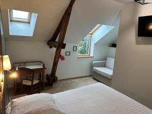a bedroom with a bed and a chair and a window at La Ferme de Maraval in Cénac-et-Saint-Julien
