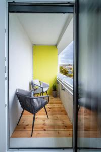 een balkon met een stoel en een gele muur bij Apartmán Chrudimpark in Chrudim