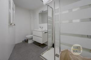 a white bathroom with a toilet and a glass shower at Excuisite New apt en Gran Via para 5pax in Madrid