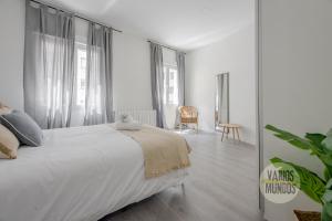 1 dormitorio blanco con 1 cama grande y ventanas en Excuisite New apt en Gran Via para 5pax en Madrid