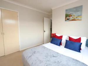 um quarto com uma cama com almofadas azuis e vermelhas em Pass the Keys Spacious 3BR Garden Home inc Parking Oxford em Oxford