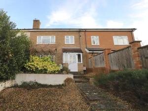 uma casa de tijolos com uma porta branca e uma cerca em Pass the Keys Spacious 3BR Garden Home inc Parking Oxford em Oxford