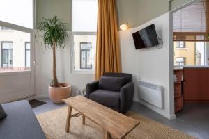 a living room with a chair and a tv at The Black Pants in Antwerp