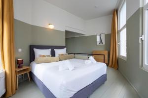 um quarto com uma cama grande e lençóis brancos em The Black Pants em Antuérpia