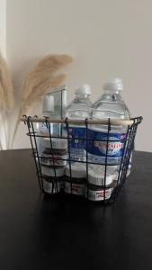 a basket filled with water bottles on a table at Le Joyau Caché Paris beautiful - Olympic games 2024 in Arnouville-lès-Gonesse