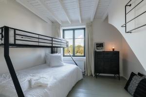a white bedroom with a bunk bed and a window at Maison Héromie - vakantiewoning Damme - 8 personen in Damme