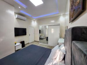 um quarto com uma cama e uma televisão de ecrã plano em F3 Appartement Point E Dakar em Dakar