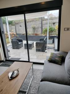 ein Wohnzimmer mit Sofa und Tisch in der Unterkunft 4MIN ORLEANS APPT 1CHB PLEIN AU CALME AVEC TERRASSE ET PARKING DEVANT in Saint-Jean-de-Braye