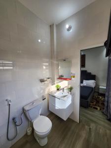 a bathroom with a white toilet and a sink at F3 Appartement Point E Dakar in Dakar