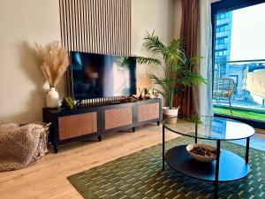 a living room with a tv and a glass table at The Snug At Pierson House in Plymouth