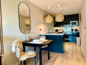 a kitchen with blue cabinets and a table and a mirror at The Snug At Pierson House in Plymouth