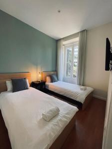 two beds in a room with a window at New Stylish Apt 5pax en la Plaza de Espana in Madrid
