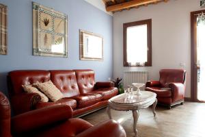 a living room with a leather couch and a table at Agriturismo Forzello in Ariano nel Polesine