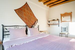 a bedroom with a large bed with purple sheets at Zen Cappadocia in Uchisar