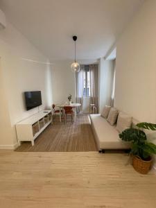 a living room with a couch and a table at Bajo Duplex 7pax a 5 min de Gran Via-Malasana in Madrid