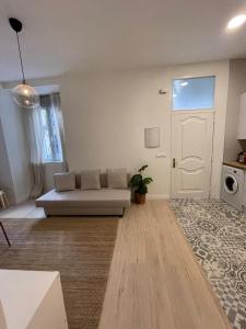 uma sala de estar com um sofá e uma porta em Bajo Duplex 7pax a 5 min de Gran Via-Malasana em Madri