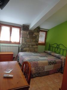 um quarto com 2 camas e uma mesa de madeira em Casa Ramona em Conques