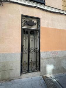 um portão preto no lado de um edifício em Bajo Duplex 7pax a 5 min de Gran Via-Malasana em Madri