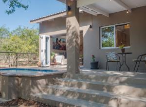 a home with a swimming pool and stairs at Wild Honey Studio in Marloth Park
