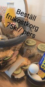 uma sanduíche e ovos numa mesa com um livro em Stuga utanför Skövde 3 em Skövde