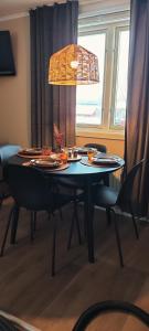 uma mesa de jantar com cadeiras e muita luz em Stuga utanför Skövde 3 em Skövde